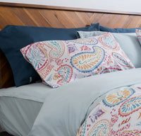 Photo of a bright, cheerful bed featuring the QuickZip fitted sheet in Dusty blue sateen cotton, ...