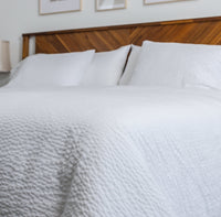 A photo of a bed made up with white ComfortCore bedding featuring the Cumulus Reversible New-Way ...