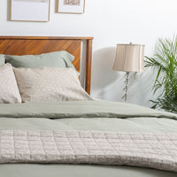 Photo of a bed styled for peace and calm wiith neutral prints and earthtones featuring the QuickZ...