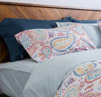 Photo of a bright, cheerful bed featuring the QuickZip fitted sheet in Dusty blue sateen cotton, ...